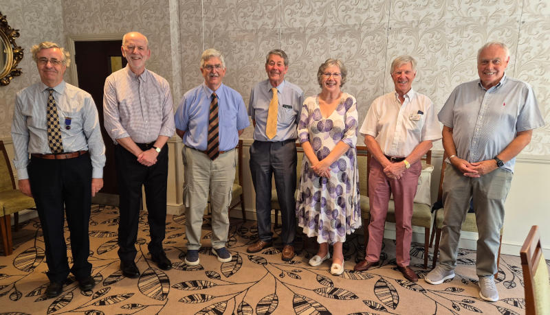 Seven smiling men and women standing in a line